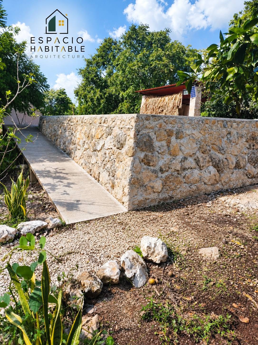 Fotografía de muros y acabados de piedra en alberca residencial